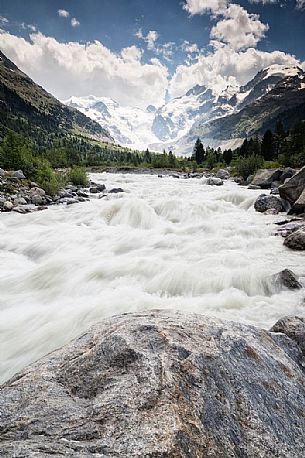 Wild creek in Val Morteratsch valley with Morteratsch Glacier and Bernina mountain group, Engadin, Pontresina, Graubunden, Switzerland, Europe
 