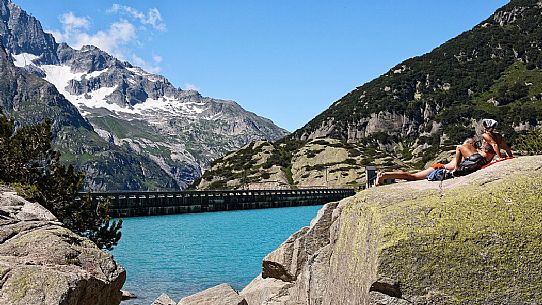 Tourists in the stone of Gelmer or Gelmersee lake, a hydroelectric reservoir, Canton of Berne, Switzerland, Europe