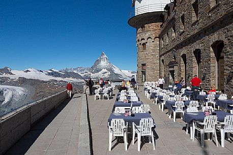 Tourists in the terrace of Klum hotel Gornergrat, in the background the  Matterhorn or Cervino mountain peak, Zematt, Valais, Switzerland, Europe
