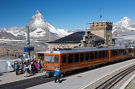 Gornergrat railway station and Swiss train, in the background  the magnificent Cervino or Matterhorn mountain peak, Zermatt, Valais, Switzerland, Europe