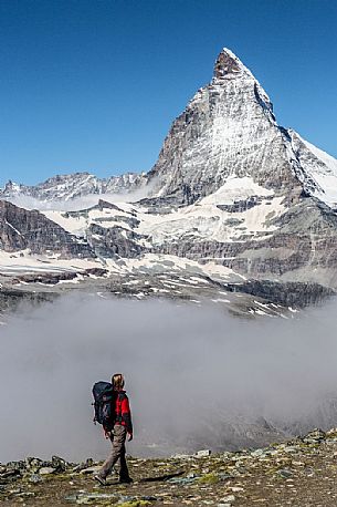 Hiker in the Gornergrat area, towards the Matterhorn or Cervino mount, Zermatt, Valais, Switzerland, Europe Hiker in the Gornergrat area, towards the Matterhorn or Cervino mount, Zermatt, Valais, Switzerland, Europe