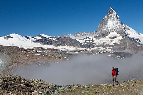 Hiker in the Gornergrat area, towards the Matterhorn or Cervino mount, Zermatt, Valais, Switzerland, Europe Hiker in the Gornergrat area, towards the Matterhorn or Cervino mount, Zermatt, Valais, Switzerland, Europe