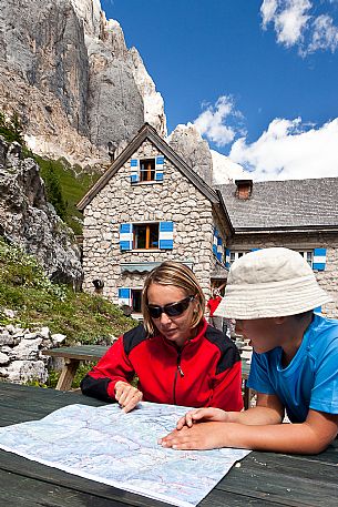 Mother looking a map with her child at the Rifugio Falier hut, below at the south cliff of Marmolada, Val Ombretta, dolomites, Veneto, Italy, Europe