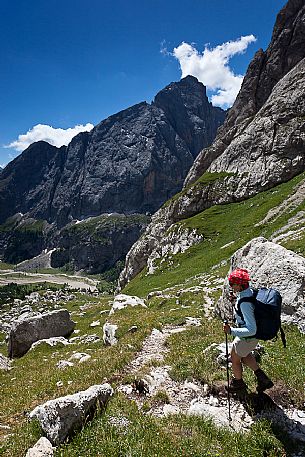 Hiker in the Marmolada mountain range, with Pian Ombretta and Ombretta valley in the background, dolomites, Veneto, Italy, Europe