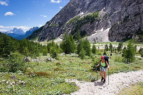 Hiker in the Marmolada mountain range, with Pian Ombretta and Ombretta valley in the background, dolomites, Veneto, Italy, Europe