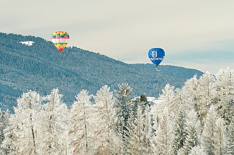 Hot air balloons flying over the Pusteria valley during the balloon festival of Dobbiaco, dolomites, Trentino Alto Adige, Italy, Europe