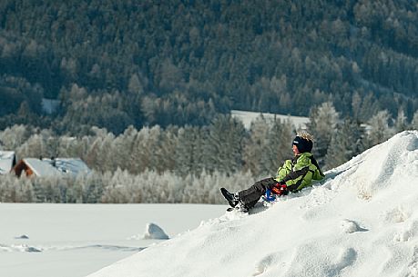 Child has fun on the snow in Fiscalina valley, Sexten, High Pusteria, dolomites, Trentino Alto Adige, Italy, Europe