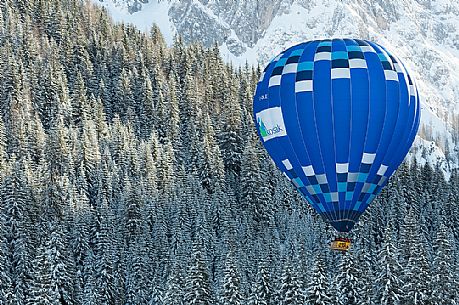 Hot air balloon flying over the Fiscalina valley during the balloon festival of Dobbiaco, Pusteria valley, dolomites, Trentino Alto Adige, Italy, Europe