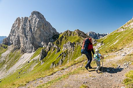 Mother and child walking in Sesis valley, in the background the Pic Chiadenis mount, Sappada, dolomites, Friuli Venezia Giulia, Italy, Europe