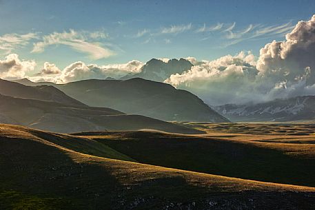 Rolling hills at sunset, Campo Imperatore and Gran Sasso d'Italia peak in the background, Gran Sasso national park, Abruzzo, Italy, Europe