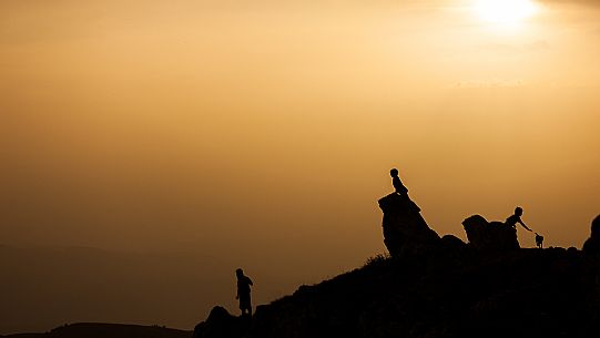 Child playing in the stones of Rocca Calascio at sunset, Gran Sasso national park, Abruzzo, Italy, Europe