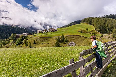 Child looking the old village of Misci on Mulini valley, Longiarù, Badia valley, Trentino Alto Adige, Italy, Europe