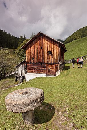 Tourists visit the ancient water mill in the Mulini valley, Longiarù, Badia valley, Trentino Alto Adige, Italy, Europe