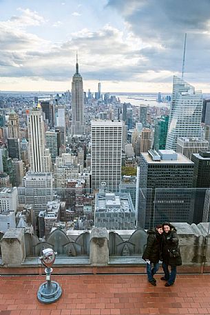 Two girls taking selfie together at the Top the Rock of Rockefeller Center towards Empire State Building, Manhattan, New York City, New York, USA