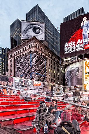 Girls sitting in the red stairs of Times Square, Manhattan, New York, United States