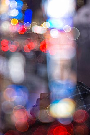 Abstract portrail of young woman in Times Square by night, Manhattan, New York, United States