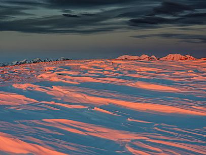 Winter sunset from the top of Pizzoc mount, in the background the peaks of Monte Cavallo mountain range, Cansiglio, Veneto, Italy, Europe