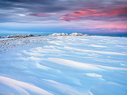 Winter sunset from the top of Pizzoc mount, in the background the peaks of Monte Cavallo mountain range, Cansiglio, Veneto, Italy, Europe