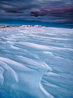 Winter twilight from the top of Pizzoc mount, in the background the peaks of Monte Cavallo mountain range, Cansiglio, Veneto, Italy, Europe