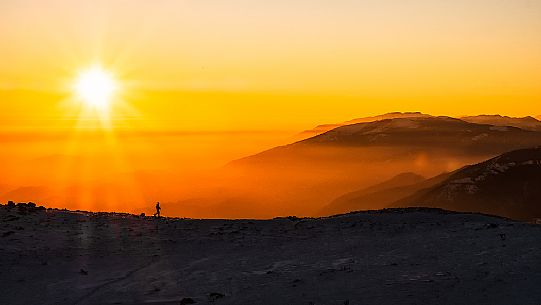 Hiking with snowshoe on the top of Pizzoc mount and in the background the Col Visentin, Cansiglio plateau, Veneto, Italy, Europe