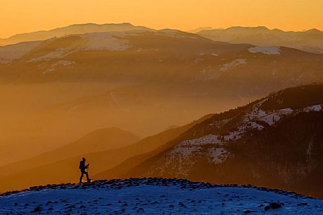 Hiking with snowshoe on the top of Pizzoc mount and in the background the Col Visentin and Montello mounts, Cansiglio plateau, Veneto, Italy, Europe