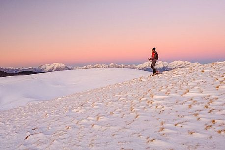 Hiking with snowshoe on the top of Pizzoc mount, in the background the Cavallo mountain range, Cansiglio, Veneto, Italy, Europe