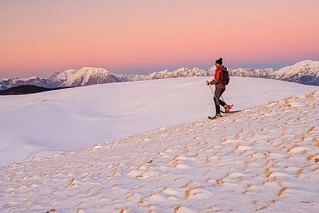 Hiking with snowshoe on the top of Pizzoc mount, in the background the Cavallo mountain range, Cansiglio, Veneto, Italy, Europe