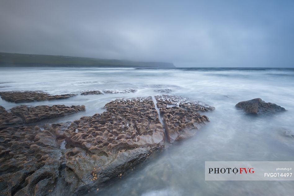 The Doolin's Pier during a storm with the cliffs of Moher in the background