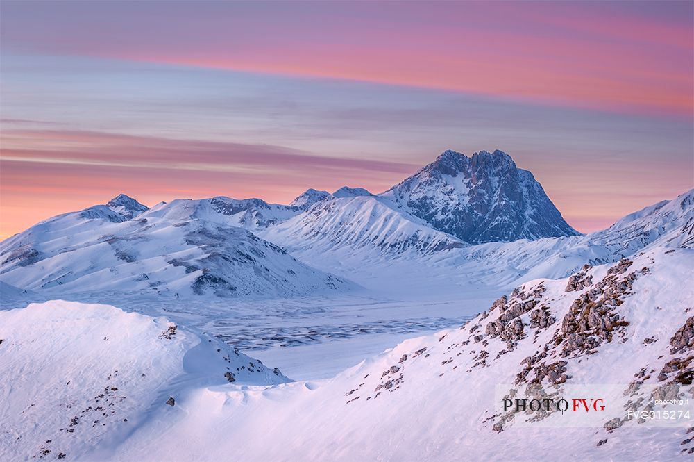 the Corno Grande Peak beyond the Mount Bolza's ridge, in Campo Imperatore, during a beautiful coloured sunset 