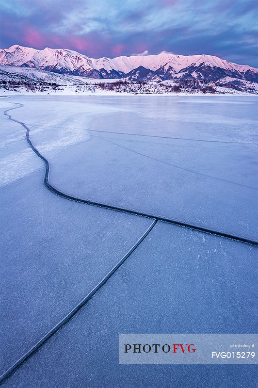 The Campotosto Lake, completely frozen in February, with cracks on the ice, Gran Sasso and Monti della Laga national park