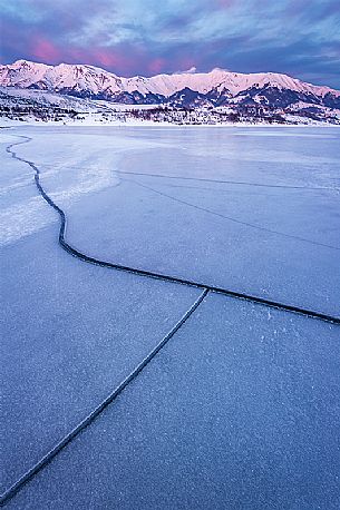 The Campotosto Lake, completely frozen in February, with cracks on the ice, Gran Sasso and Monti della Laga national park