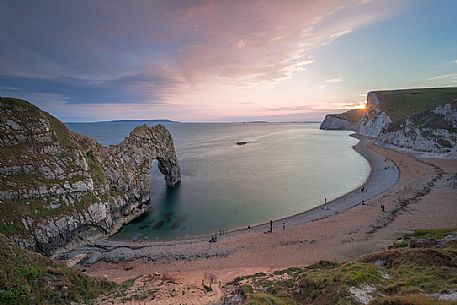 Sunset at Durdle Door, a natural limestone arch on the Jurassic coast near Lulworth in Dorset, England, UK