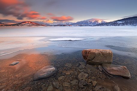 The lake of Campotosto at sunset in late winter during the thawing of the surface of the lake, Gran Sasso national park, Abruzzo, Italy, Europe