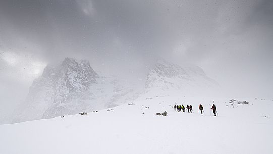 A group of hikers proceed towards the Gran Sasso during a snowstorm, Gran Sasso national park, Abruzzo, Italy, Europe
