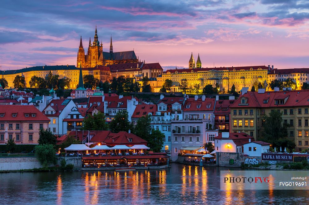 Prague, view across Vltava River and Charles Bridge towards Hradcany Castle and St. Vitus Cathedral at sunset

