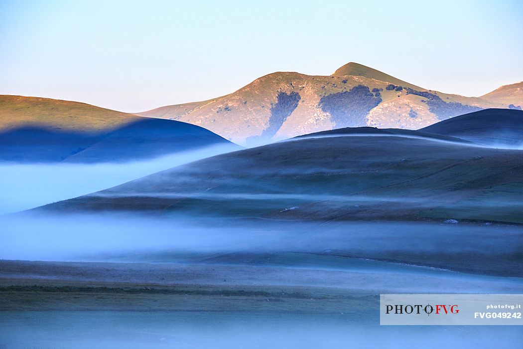 Special effects of the fog at Pian Piccolo at the first light of the morning, Sibillini mountains, Castelluccio di Norcia, Umbria, Italy.