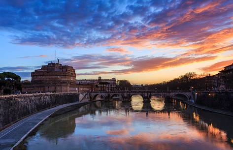 A colored dawn with the reflex of the sky on the river Tevere and the silohuette of Castel Sant'Angelo and the Sant'Angelo bridge