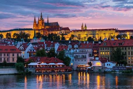 Prague, view across Vltava River and Charles Bridge towards Hradcany Castle and St. Vitus Cathedral at sunset
