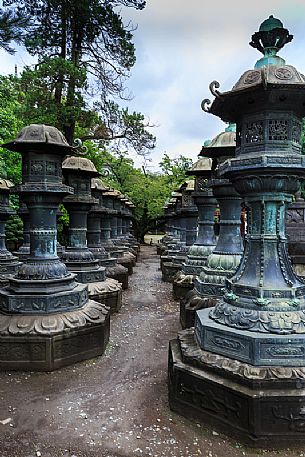 Alley with bronze lanterns to the Tōshō-gū Shinto or Toshogu shrine temple in Ueno park, Tokyo, Japan
