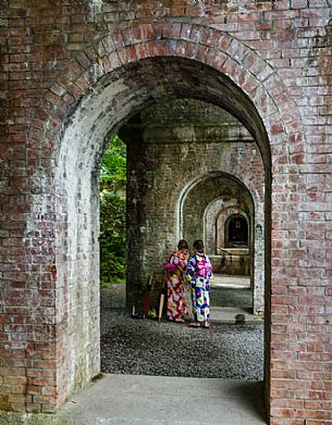 Two Japanese girls in kimono under the arches of the ancient aqueduct of the Nanzen ji temple in Kyoto, Japan