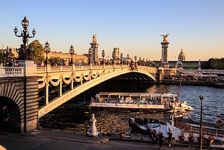 The Alexander III bridge at sunset while passing a Bateau Mouche, Paris, France, Europe