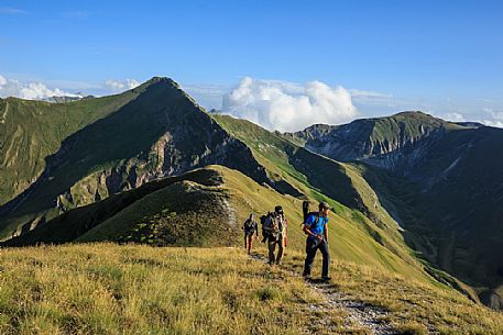 Photographers going up to Pizzo Tre Vescovi from Passo del Fargno, in the background Pizzo Berro, Monti Sibillini national park, Marche, Italy, Europe