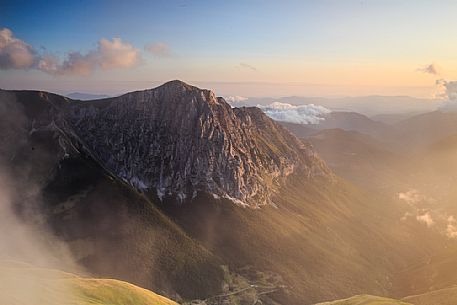 Sunset from the top of Pizzo Tre Vescovi peak towards the rocky wall of Monte Bove mount, Sibillini national park, Marche, Italy, Europe
