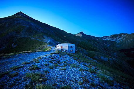 Night view of the Fargno pass with the refuge and Pizzo Tre Vescovi peak in the background, Sibillini national park, Ussita, Marche, Italy, Europe