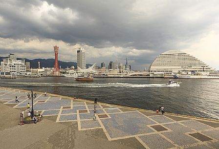 View of Takahama Wharf in Kobe Harborland  before a storm at sunset. On the left is visible the red skyline Kobe Port Tower, Japan