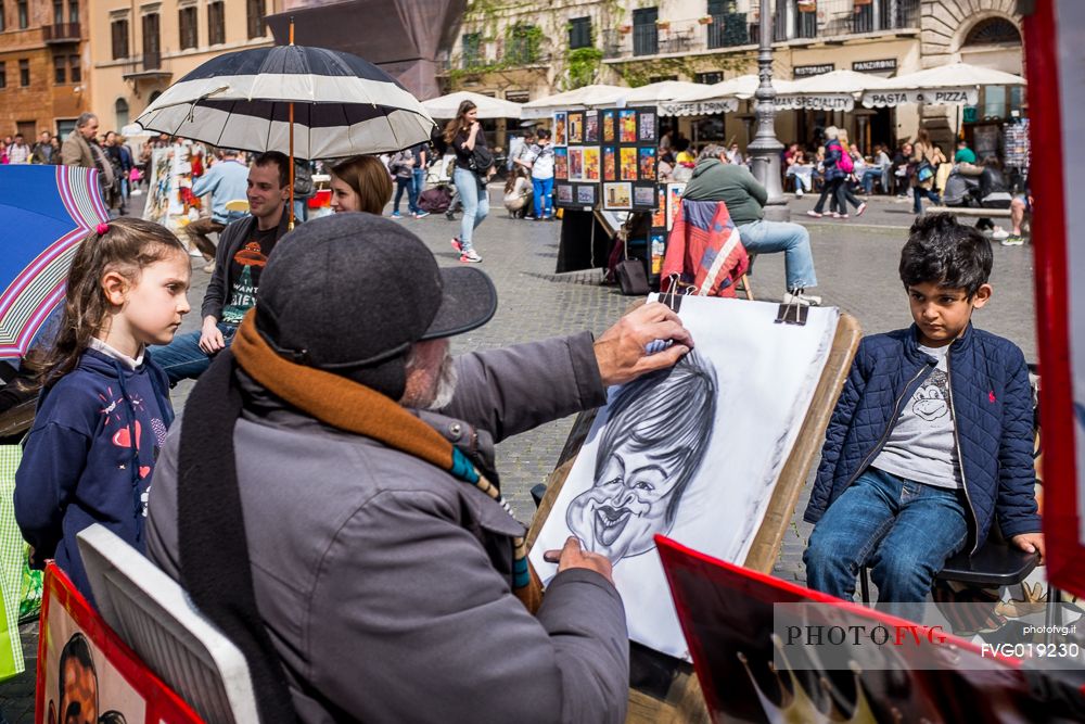 A street artist portrays a children in Piazza Navona.