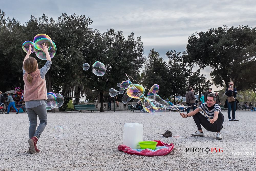 A street artist make soap bubbles for children in Pincio's terrace.