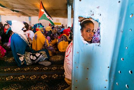A young girl sitting on the floor during a meeting in the refugee camp of Dahkla