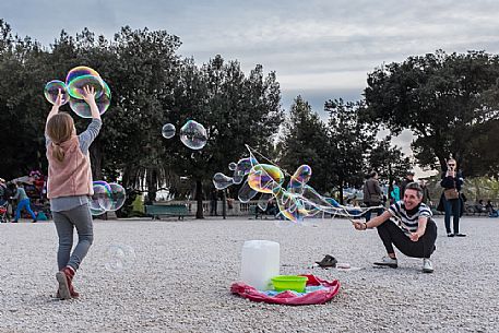 A street artist make soap bubbles for children in Pincio's terrace.