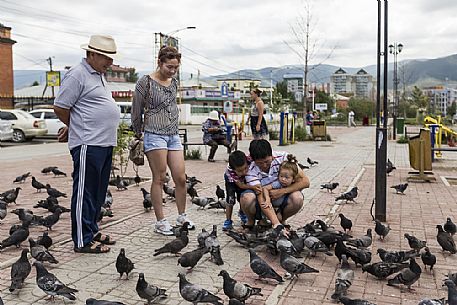 Some people playing with pigeons in front of Gandantegchinlen Khiid monastery, Mongolia